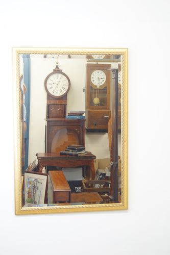 A decorative Vintage Italian gilt mirror with an antiqued finish