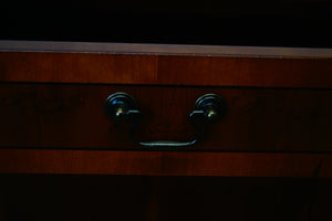 A golden Yew console table with two drawers at the top and a cupboard below