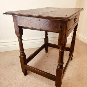 A period oak side table dating from the early 18th century, with a pegged two plank top