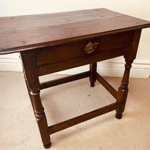 A period oak side table dating from the early 18th century, with a pegged two plank top