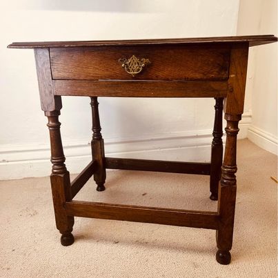 A period oak side table dating from the early 18th century, with a pegged two plank top