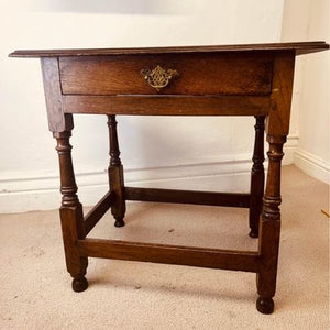 A period oak side table dating from the early 18th century, with a pegged two plank top