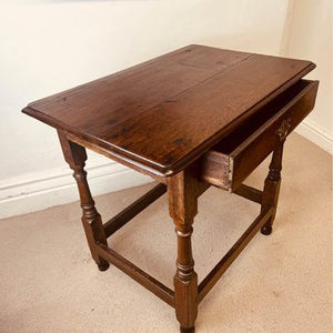 A period oak side table dating from the early 18th century, with a pegged two plank top