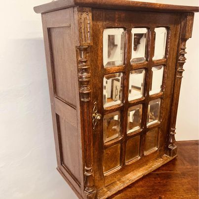 A fantastic solid oak cabinet with twelve individual double bevelled glass panel