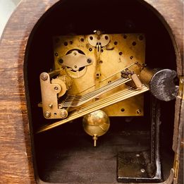 An ornate mahogany wooden Napoleon Hat mantle clock with Westminster chime