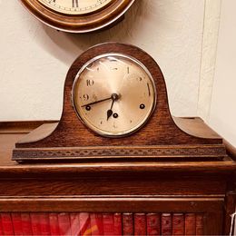 An ornate mahogany wooden Napoleon Hat mantle clock with Westminster chime