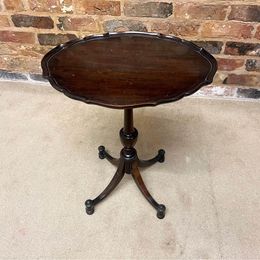 Antique oval mahogany wine table ,the carved piecrust top above a revolving turned stem