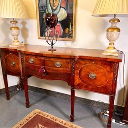 An outstanding solid mellow mahogany serpentine sideboard by renowned 'Titchmarsh and Goodwin'