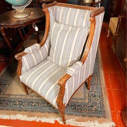 A French Louis XVI style walnut bergères chair from the 20th century in fabulous condition