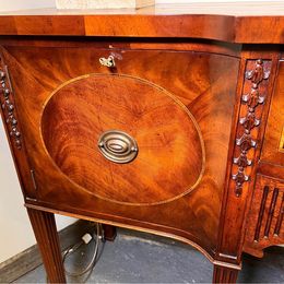 An outstanding solid mellow mahogany serpentine sideboard by renowned 'Titchmarsh and Goodwin'