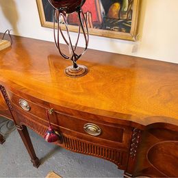 An outstanding solid mellow mahogany serpentine sideboard by renowned 'Titchmarsh and Goodwin'