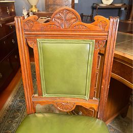 An antique decorative carved and turned Victorian leather office chair