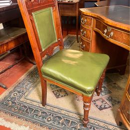 An antique decorative carved and turned Victorian leather office chair