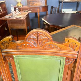 An antique decorative carved and turned Victorian leather office chair