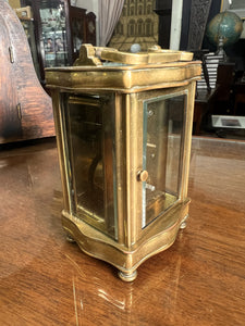 A handsome fully glazed classic Corniche style polished brass carriage clock with a fine white enamel dial