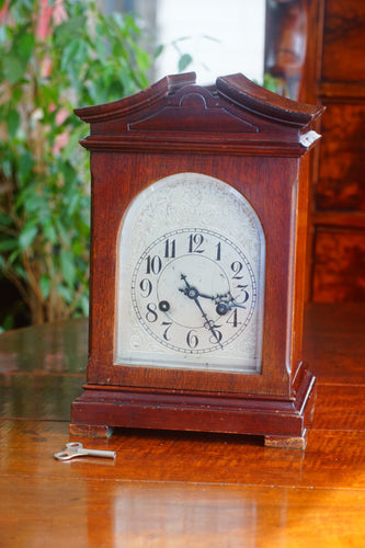 A mahogany mantle clock with the most fabulously engraved face