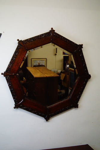 A solid mahogany carved octagonal mirror with double bevelled edged glass