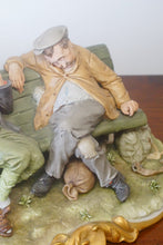 Load image into Gallery viewer, A splendid large porcelain Capodimonte sculpture representing two drunken tramps sat on a bench