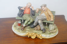 Load image into Gallery viewer, A splendid large porcelain Capodimonte sculpture representing two drunken tramps sat on a bench