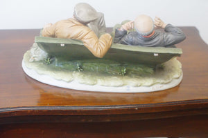 A splendid large porcelain Capodimonte sculpture representing two drunken tramps sat on a bench